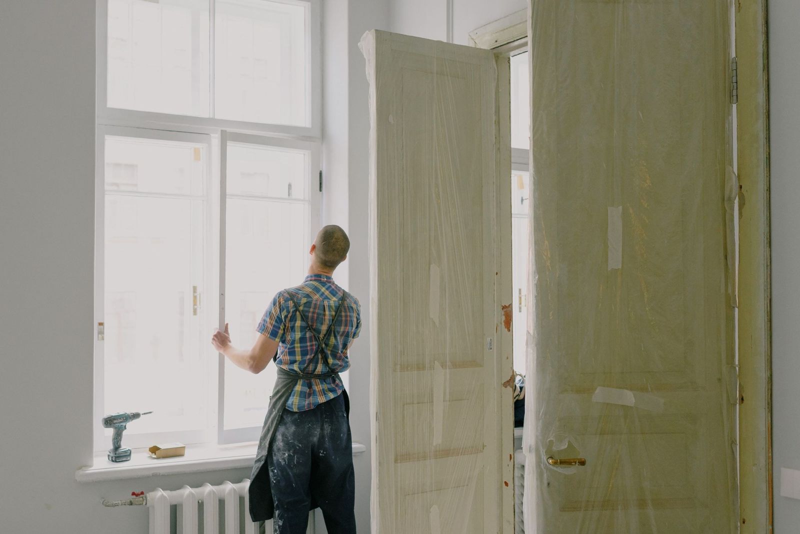 Handwerker montiert ein Fenster mit der Bohrmaschine