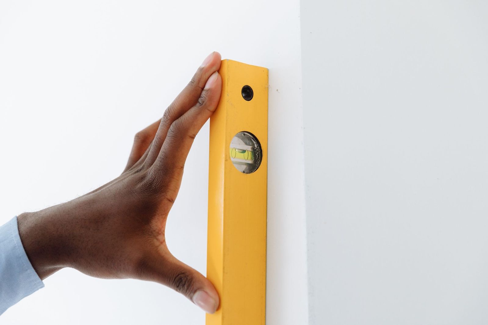 Hand richtet eine Wasserwaage an der Wand aus